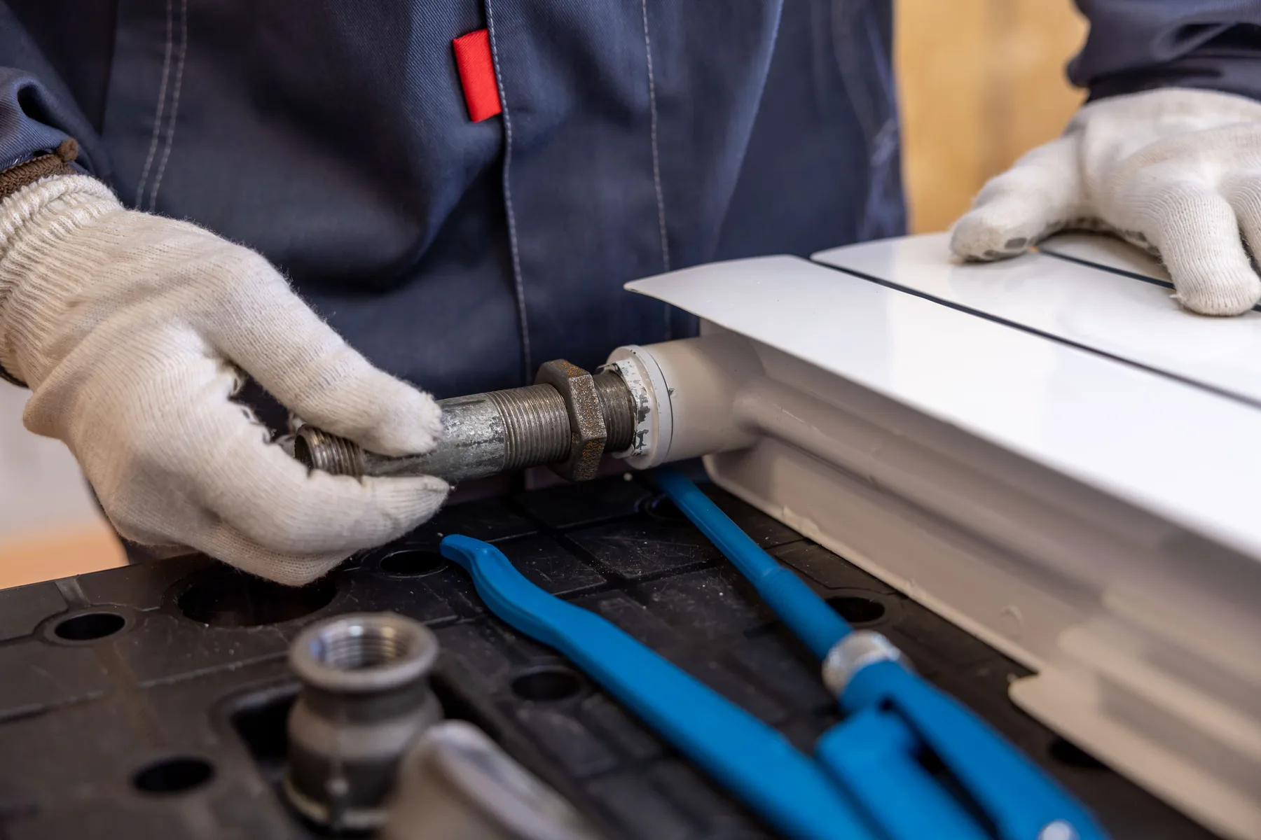 Stock close-up photo of a technician working on a pipe connection
